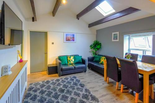 a living room with a couch and a table at Headingley 2 Bedroom first floor cottage flat Near Universities shops& Park in Leeds