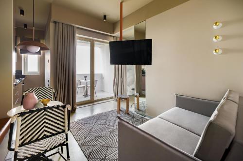 a living room with a couch and a tv at Rezident Tomis Marina in Constanţa