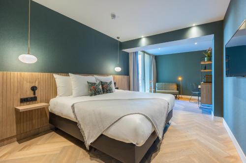 een slaapkamer met een groot bed met een groene muur bij Van der Valk hotel Den Haag Wassenaar in Wassenaar