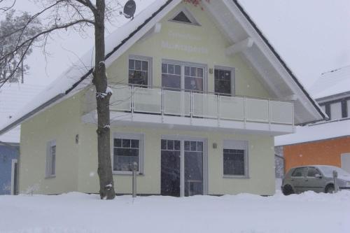 une maison dans la neige avec dans l'établissement Ferienhaus Müritzperle, à Marienfelde