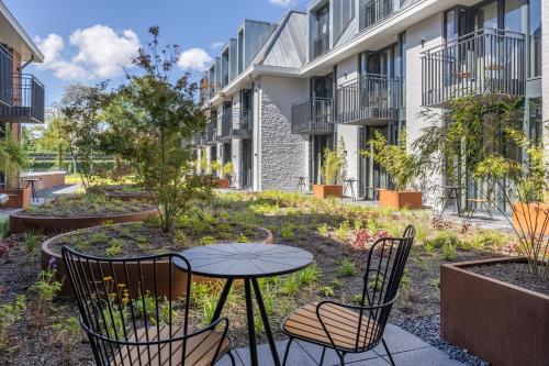 eine Terrasse mit einem Tisch und Stühlen vor einem Gebäude in der Unterkunft Van der Valk hotel Den Haag Wassenaar in Wassenaar