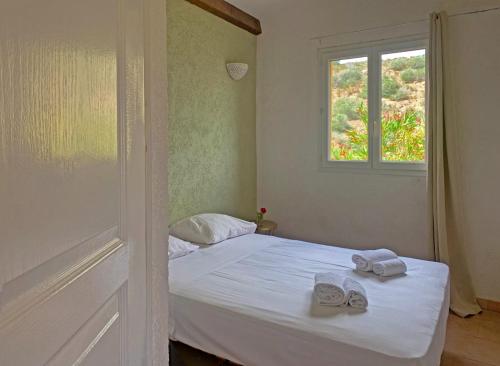 a bedroom with a bed with two slippers on it at Résidence Maora Village in Bonifacio