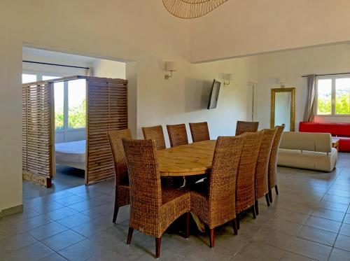 a dining room with a wooden table and chairs at Résidence Maora Village in Bonifacio