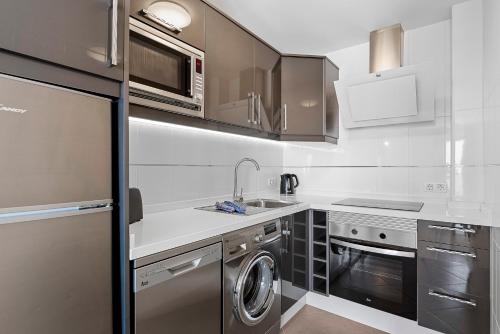 a kitchen with a sink and a dishwasher at Paloma Beach Apartments in Los Cristianos