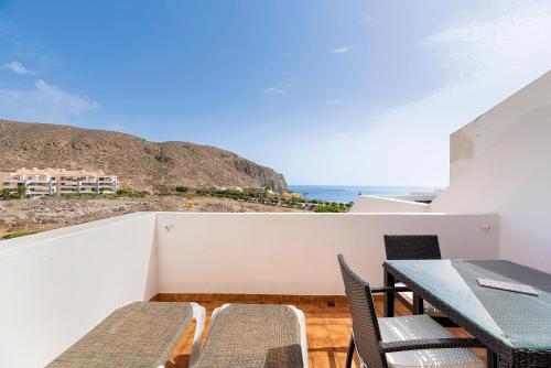 a balcony with a table and chairs and the ocean at Paloma Beach Apartments in Los Cristianos