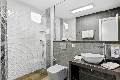 a bathroom with a sink and a toilet and a shower at Paloma Beach Apartments in Los Cristianos