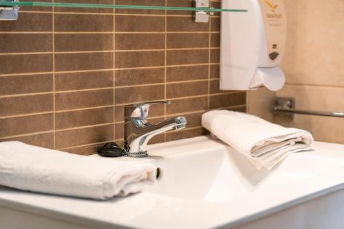 a bathroom sink with white towels on it at Paloma Beach Apartments in Los Cristianos