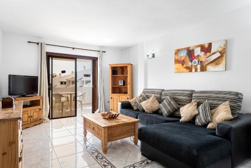 a living room with a couch and a coffee table at Paloma Beach Apartments in Los Cristianos