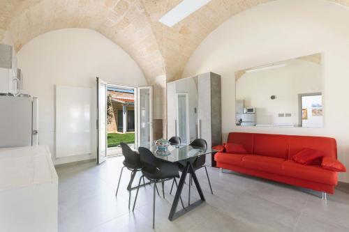 a living room with a red couch and a table at Villa Queen by Perle di Puglia in Lecce