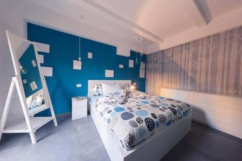 - une chambre bleue avec un lit et un mur bleu dans l'établissement CA’ De La Torre, à Bologne