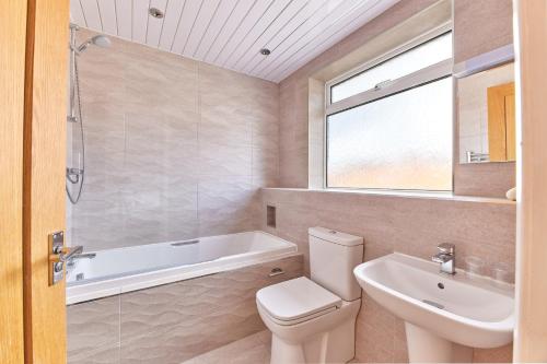 a bathroom with a toilet and a sink and a bath tub at Properties Unique Dene Rooms - Double Room in Newcastle upon Tyne