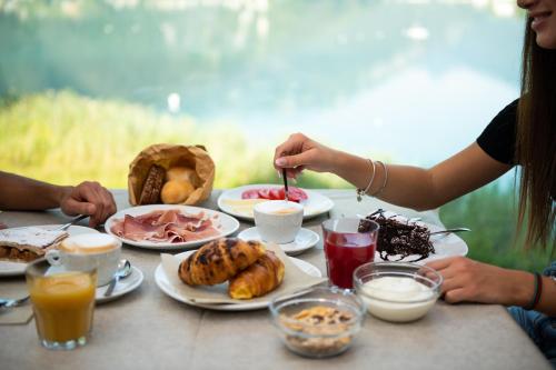 a group of people sitting at a table with food at Panoramic Hotel San Carlo Ledro in Ledro