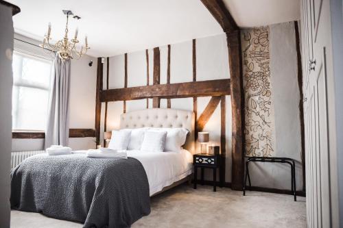 a bedroom with a large white bed and a chandelier at Taylour House - Edenbridge in Kent