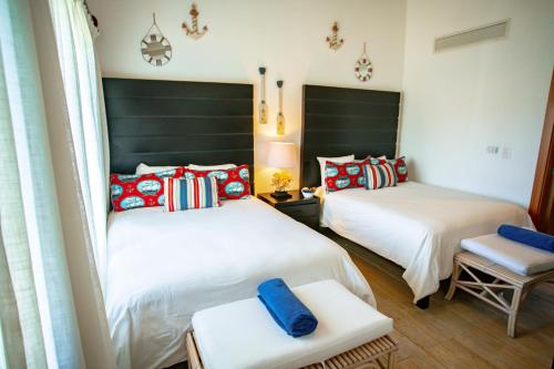 a bedroom with two beds and a chair in it at Xeliter Balcones del Atlantico - Las Terrenas in Las Terrenas