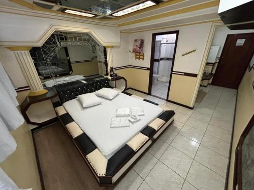 a bedroom with a large bed and a mirror at Apice Motel Itu (adults only) in Itu