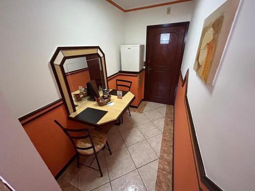 a room with a desk with a mirror and a table at Apice Motel Itu (adults only) in Itu