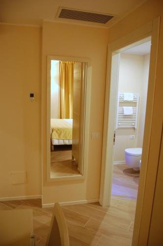 a bathroom with a mirror and a bed and a toilet at La Corte Fiorita Como in Como