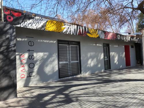 un edificio blanco con una pintura a un lado en DAKAR HOSTEL en Mendoza