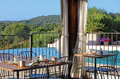 two tables and chairs on a balcony with a view at Résidence Maora Village in Bonifacio