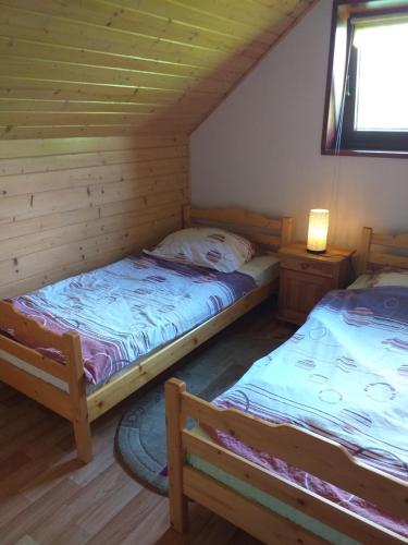 a bedroom with two beds in a log cabin at Chatka Milkowska in Wisła