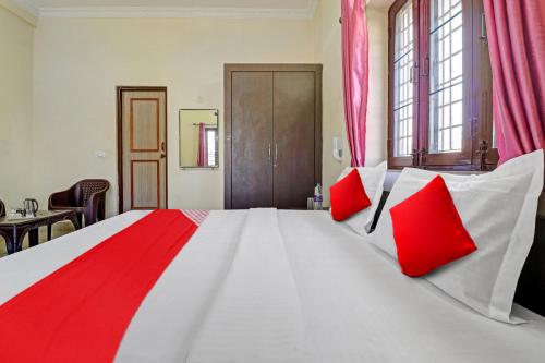 a large bedroom with a large bed with red pillows at Balindira Guest House in Dehradun