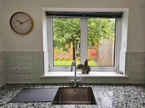 um lavatório de cozinha com uma janela e um relógio em The Queen’s apartments em Londres
