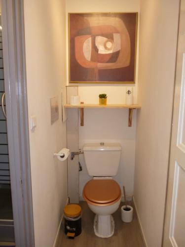 een badkamer met een toilet en een foto aan de muur bij Mousse appartement à Sangatte au premier étage à 50 metres de la plage in Sangatte