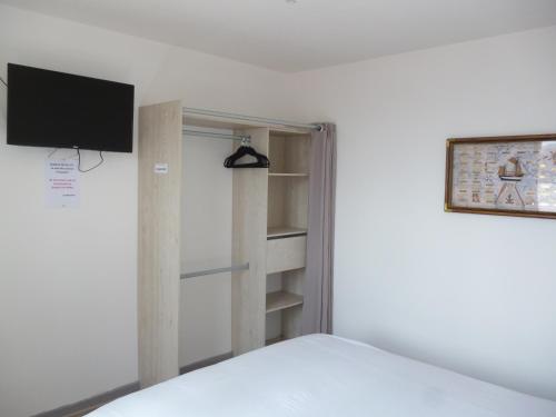 サンガットにあるMousse appartement à Sangatte au premier étage à 50 metres de la plageのベッドと壁掛けテレビのある寝室