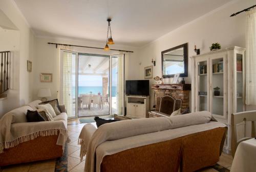 a living room with a couch and a view of the ocean at Beachfront Villa Dionysos - With private beach in Sidari