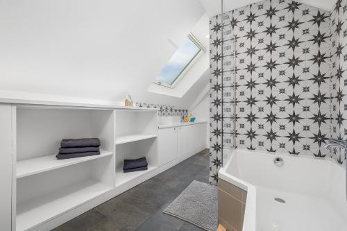 uma casa de banho com uma banheira branca e um chuveiro em la Zinguerie de la Plage - plage 300m, babyfoot, arcade, familial et design em Saint-Pair-sur-Mer