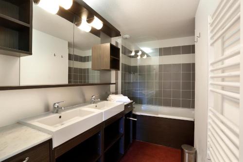 a bathroom with two sinks and a mirror at Vacancéole - Les Chalets du Verdon in La Foux