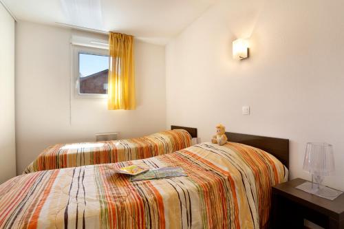 a bedroom with two beds and a window at Vacancéole - Les Chalets du Verdon in La Foux