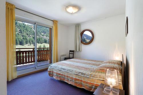 - une chambre avec un lit et une grande fenêtre dans l'établissement Vacancéole - Les Chalets du Verdon, à La Foux