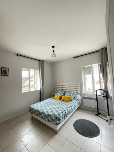 1 dormitorio con 1 cama y 2 ventanas en Famille SABLJAK, en Marles-en-Brie