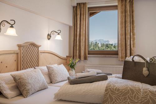 a bedroom with a large bed with a window at Biohotel Rastbichlhof in Neustift im Stubaital