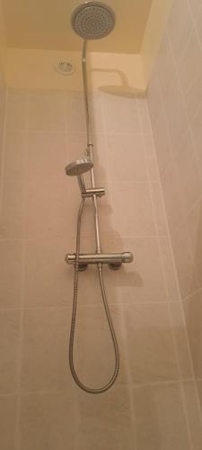 La salle de bains est pourvue d'une douche avec un pommeau de douche. dans l'établissement Super Appartement, à La Souterraine