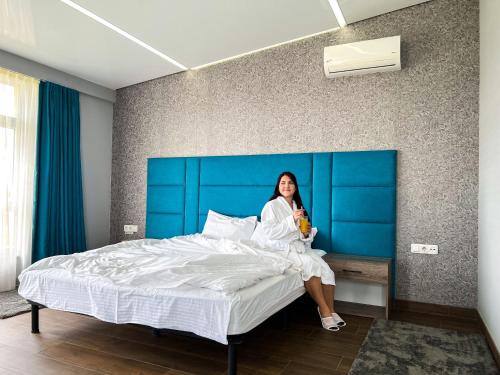 a woman sitting on top of a bed at Aleanda in Chernivtsi