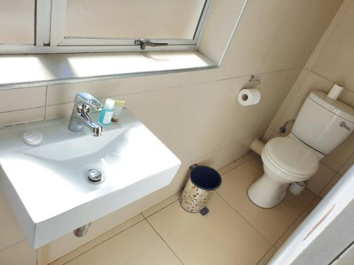 a bathroom with a white sink and a toilet at Cube Hotel in Durban