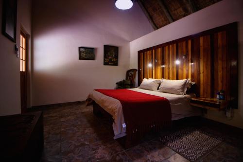 a bedroom with a large bed with a red blanket at Uitkyk Guest Farm in Usakos