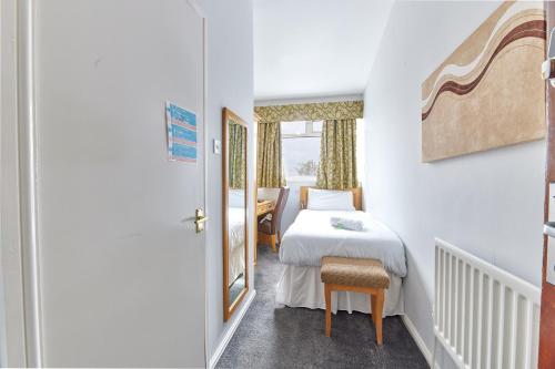 ein kleines Zimmer mit einem Bett, einem Stuhl und einem Fenster in der Unterkunft Properties Unique Dene Rooms - Single Room in Newcastle upon Tyne