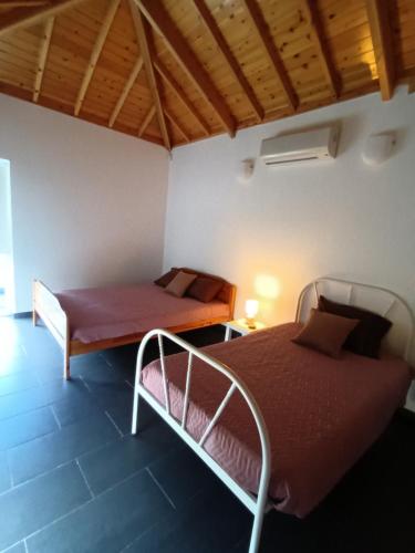 een slaapkamer met 2 bedden in een kamer bij Casa dos Biscoitos in Praia da Vitória