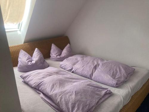 a bed with purple sheets and pillows on it at Alter Rhin in Kietz