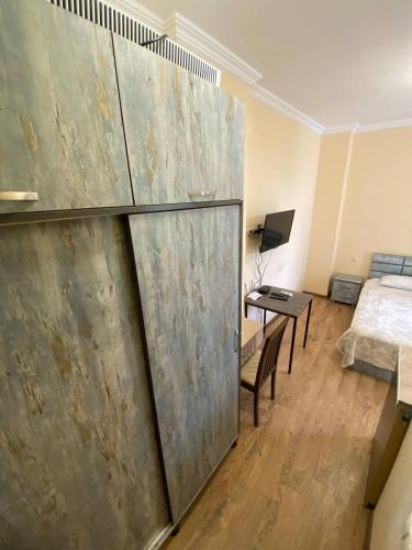 a large metal wall in a room with a bed and a desk at Квартира у моря Колхида in Makhinjauri