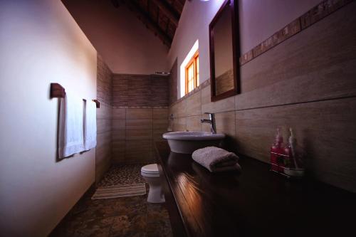 ein Bad mit einem Waschbecken und einem WC in einem Zimmer in der Unterkunft Uitkyk Guest Farm in Usakos