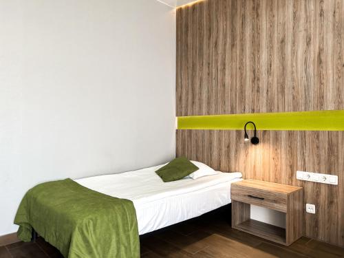 a small bedroom with a bed and a wooden wall at Aleanda in Chernivtsi