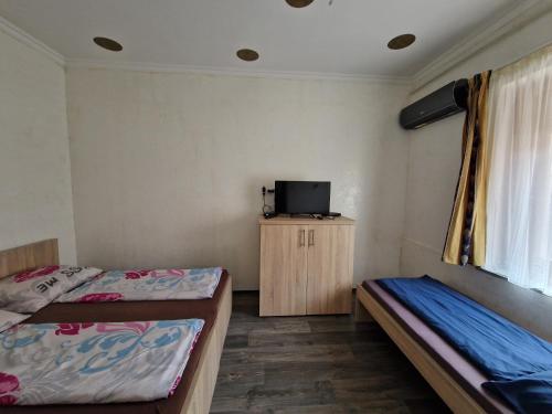 a room with two beds and a tv in it at Bem Downtown Apartment in Debrecen