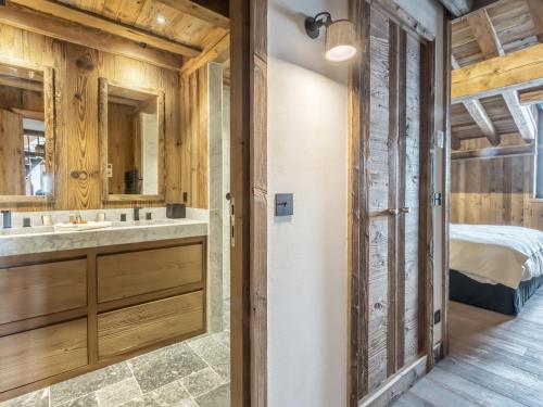 une salle de bain avec un lit, un lavabo et un miroir dans l'établissement Duplex 5 pièces luxe aux pieds des pistes avec hammam et cheminée - FR-1-694-87, à Val dʼIsère