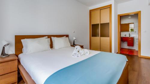 um quarto com uma cama grande e toalhas em Luminous 2 BDR Apartment W/Pool by LovelyStay nos Olhos de Água