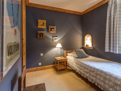 a bedroom with a bed with a blue wall at Appartement Val-d'Isère, 5 pièces, 8 personnes - FR-1-694-106 in Val-d'Isère