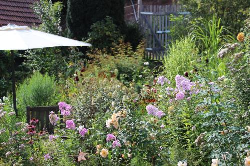 a garden with purple flowers and an umbrella at The Moosbach Garden in Nordrach
